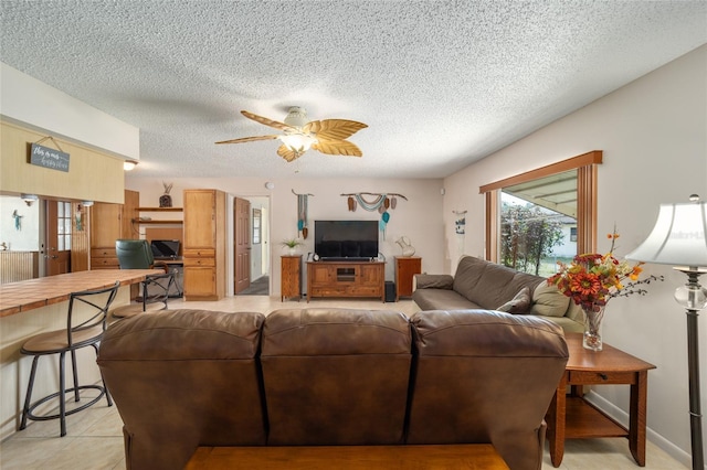 living area featuring light tile patterned floors, a textured ceiling, and a ceiling fan