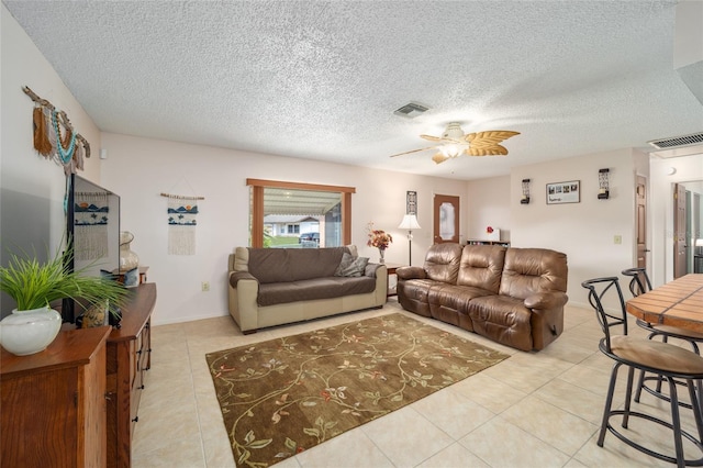 living room with visible vents, a textured ceiling, ceiling fan, and tile patterned flooring