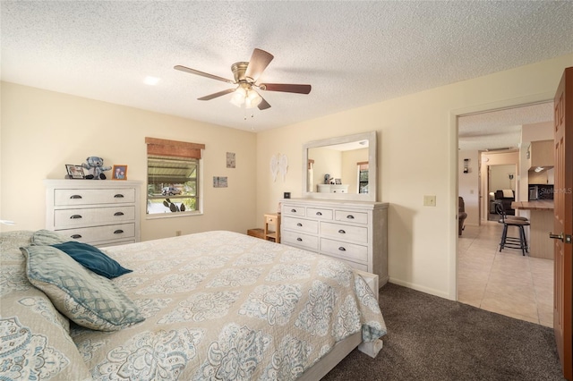 carpeted bedroom featuring tile patterned flooring, ceiling fan, baseboards, and a textured ceiling