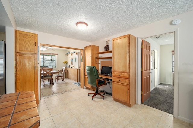 office area featuring light tile patterned flooring, baseboards, and a textured ceiling