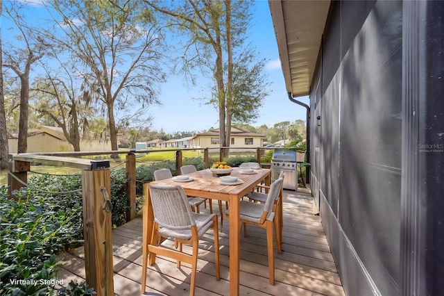 deck with outdoor dining space and a grill