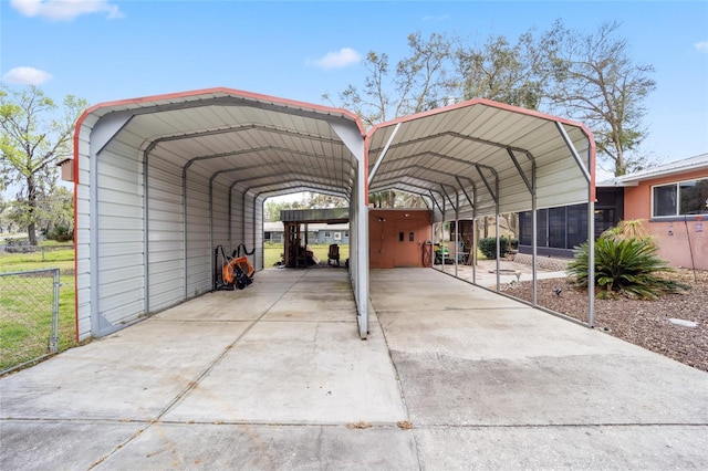 view of vehicle parking featuring a carport, driveway, and fence