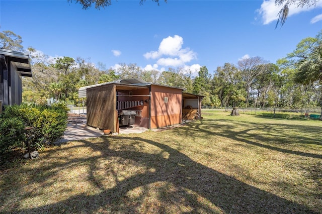 view of yard featuring an outdoor structure and fence