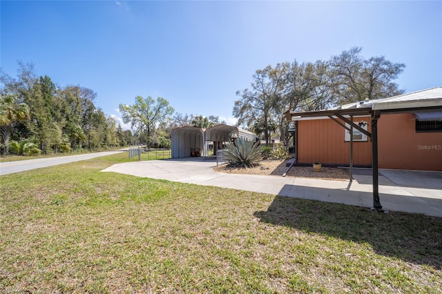 view of yard with a carport and concrete driveway