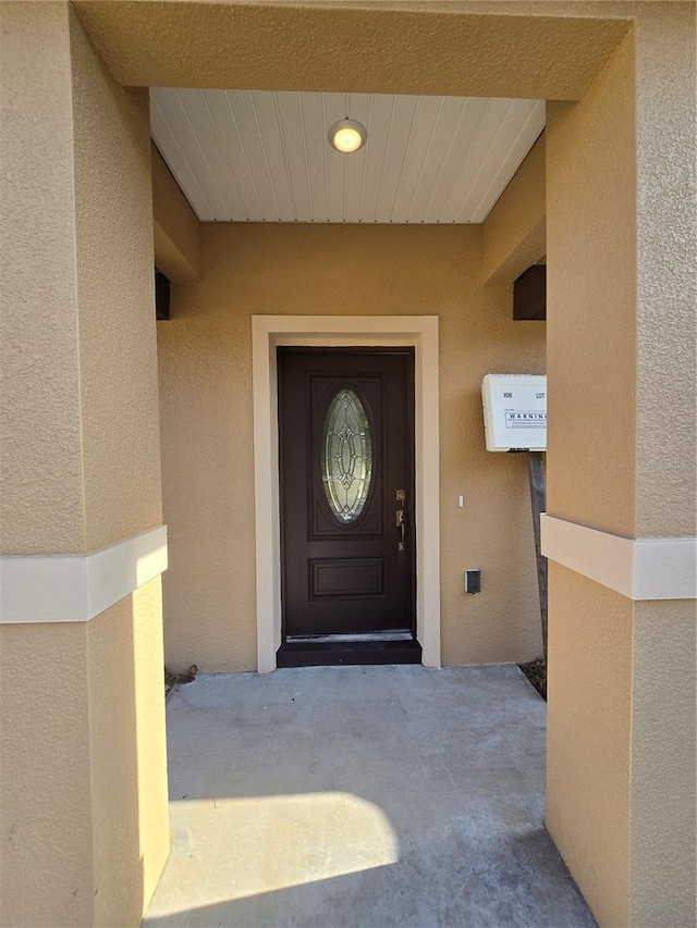 property entrance with stucco siding