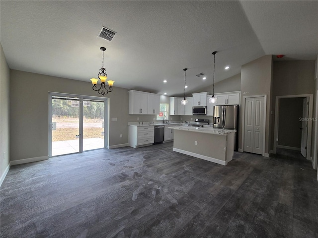 kitchen with visible vents, stainless steel appliances, light countertops, white cabinetry, and a center island