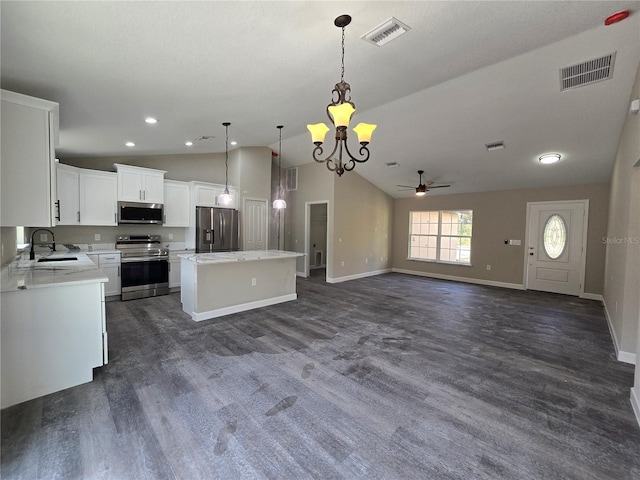 kitchen featuring visible vents, a kitchen island, light countertops, stainless steel appliances, and a sink