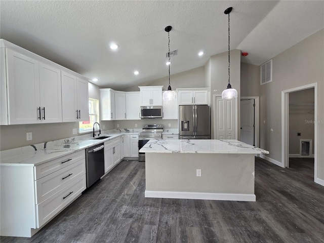 kitchen with visible vents, appliances with stainless steel finishes, a kitchen island, and a sink