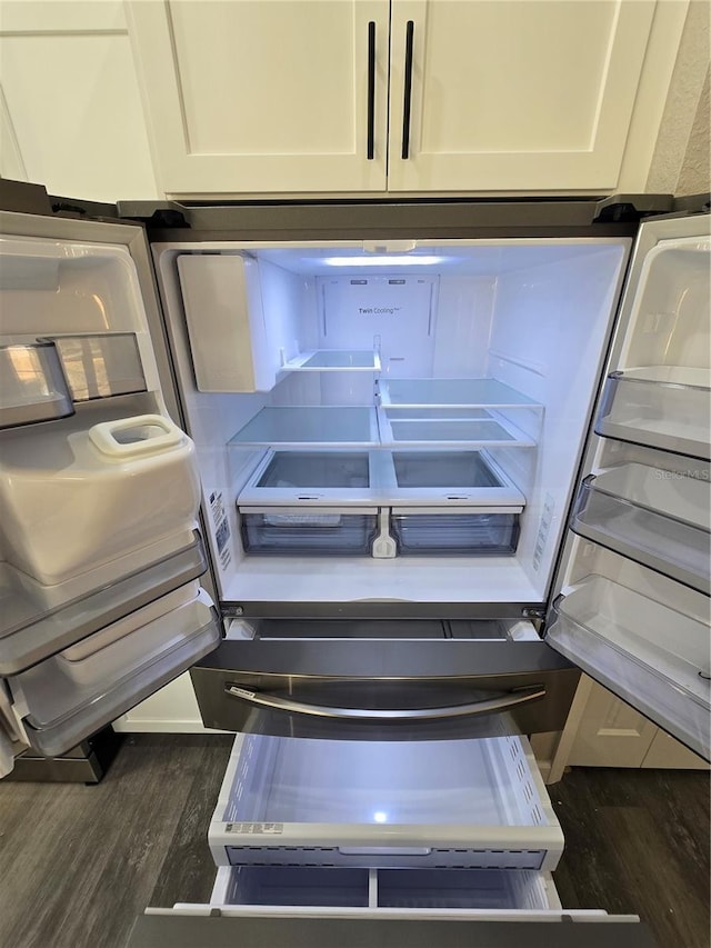 details with refrigerator, dark wood-style flooring, and white cabinetry