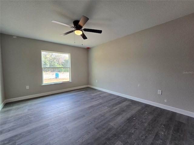 unfurnished room with dark wood finished floors, ceiling fan, a textured ceiling, and baseboards