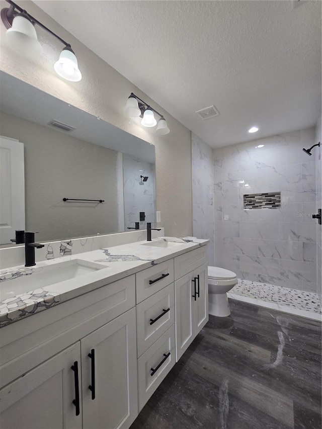 full bath featuring visible vents, toilet, wood finished floors, and a sink