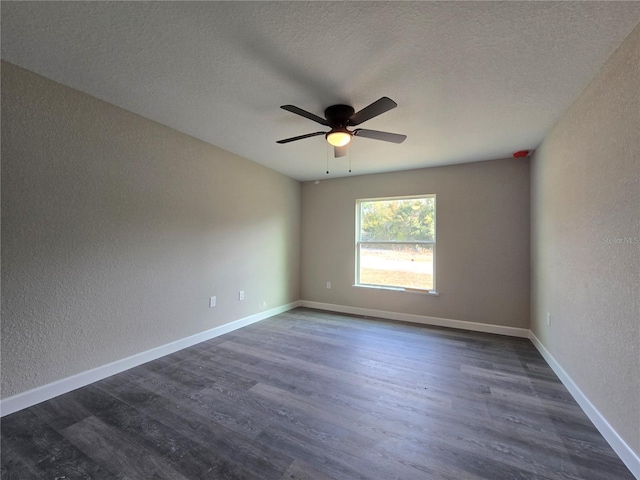 empty room with baseboards, a textured ceiling, dark wood-style flooring, and a textured wall