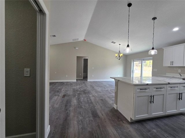 kitchen with dark wood-type flooring, white cabinets, baseboards, and vaulted ceiling