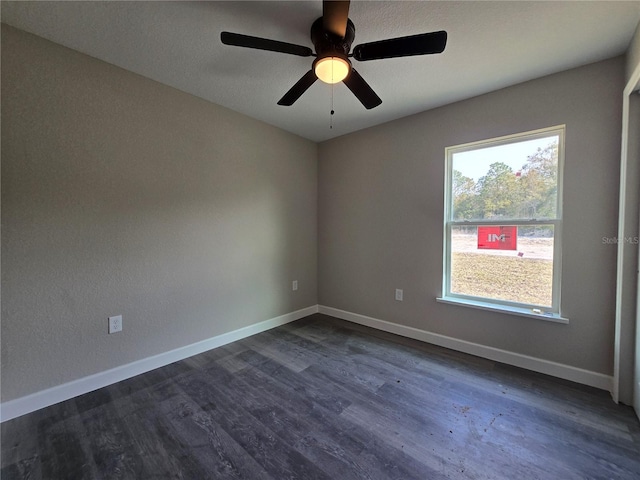 spare room with ceiling fan, baseboards, and dark wood finished floors