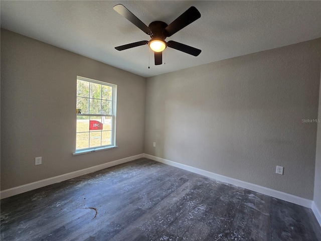 spare room featuring baseboards, a textured ceiling, and wood finished floors