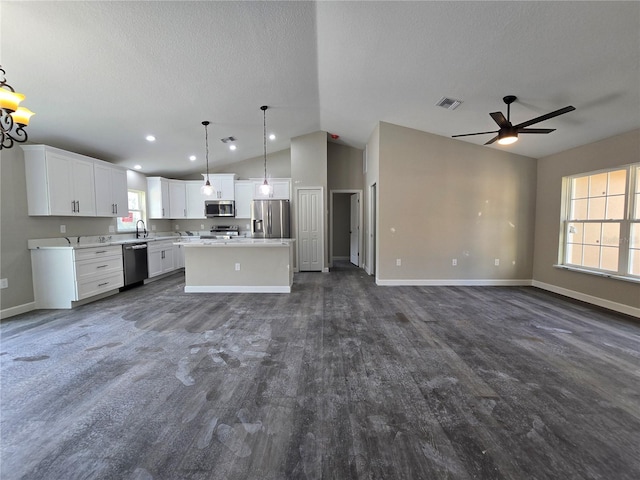 kitchen with open floor plan, appliances with stainless steel finishes, a kitchen island, and visible vents