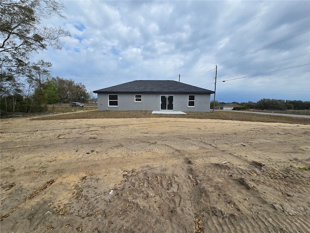 rear view of property featuring stucco siding