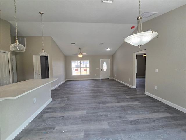 unfurnished living room featuring vaulted ceiling, baseboards, and dark wood-style flooring