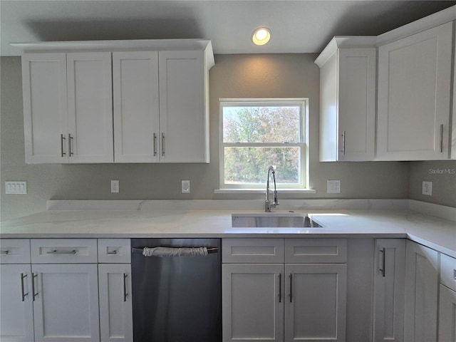 kitchen featuring dishwasher, white cabinetry, light countertops, and a sink