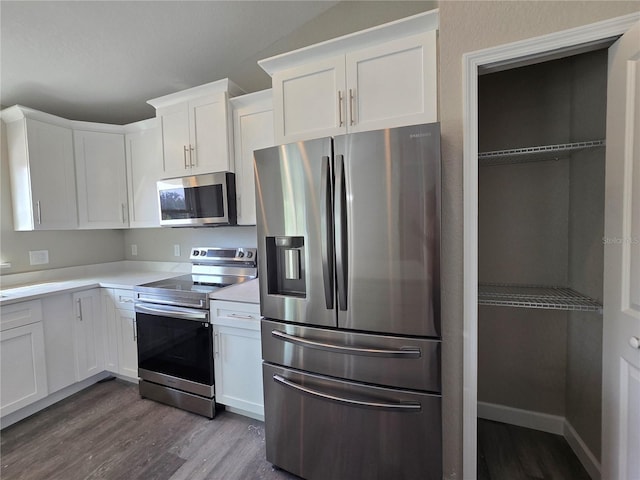 kitchen with baseboards, dark wood finished floors, light countertops, stainless steel appliances, and white cabinetry