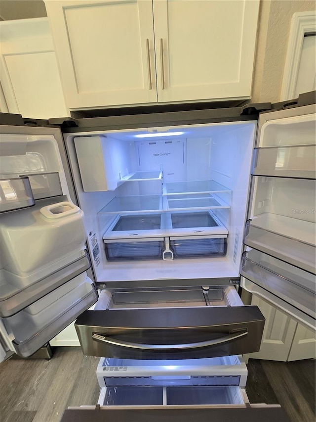 details featuring fridge, wood finished floors, and white cabinets