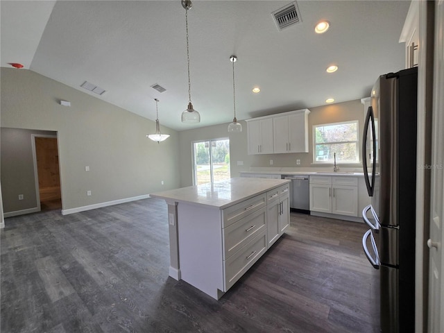 kitchen featuring visible vents, a sink, appliances with stainless steel finishes, white cabinets, and lofted ceiling