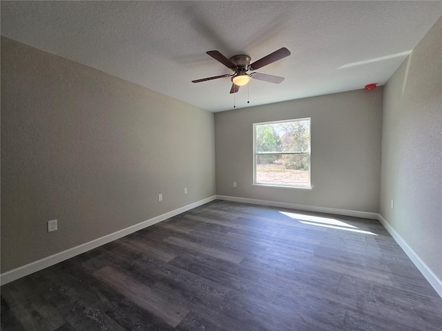 spare room with dark wood finished floors, a ceiling fan, baseboards, and a textured ceiling