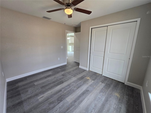 unfurnished bedroom featuring a ceiling fan, visible vents, wood finished floors, baseboards, and a closet