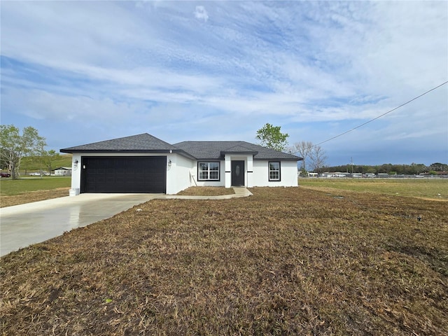 view of front of house with stucco siding, a front lawn, concrete driveway, and a garage