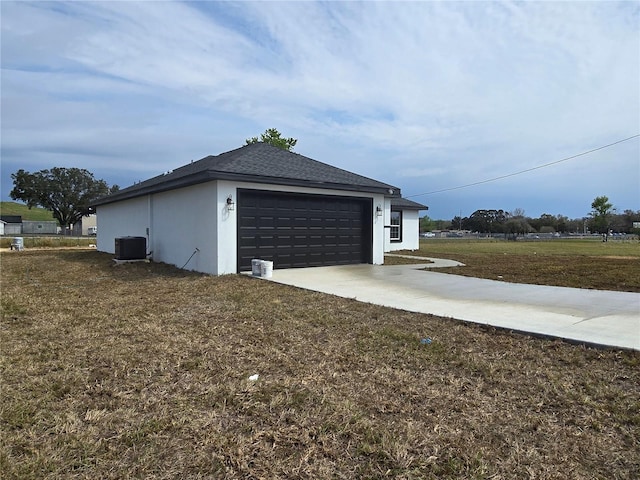 garage featuring concrete driveway and central AC