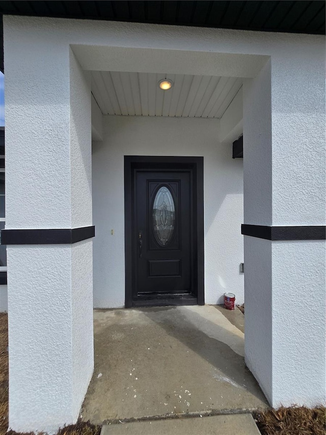 entrance to property with stucco siding