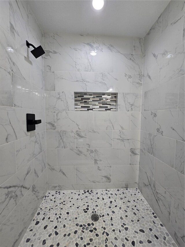 full bath with a tile shower