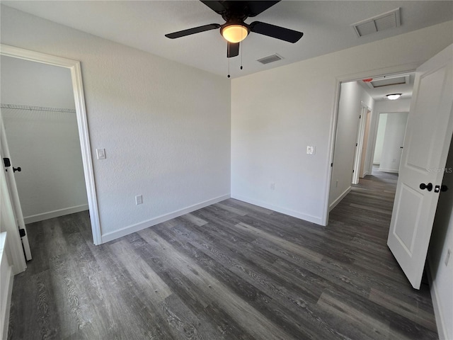 unfurnished bedroom with visible vents, baseboards, and dark wood finished floors