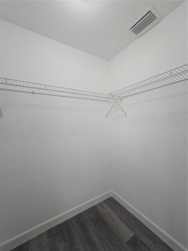 spacious closet featuring dark wood finished floors and visible vents