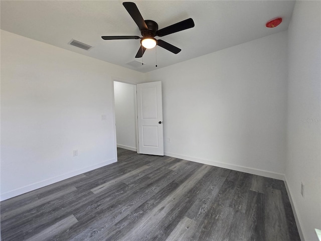 empty room featuring dark wood finished floors, baseboards, visible vents, and ceiling fan