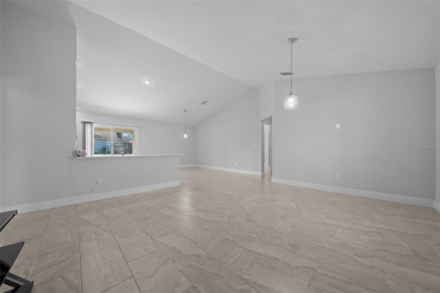 unfurnished living room with baseboards and vaulted ceiling