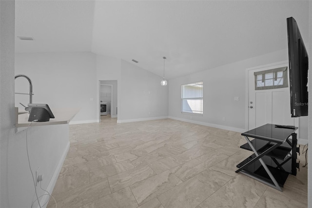 living room with baseboards, marble finish floor, washer / dryer, and vaulted ceiling