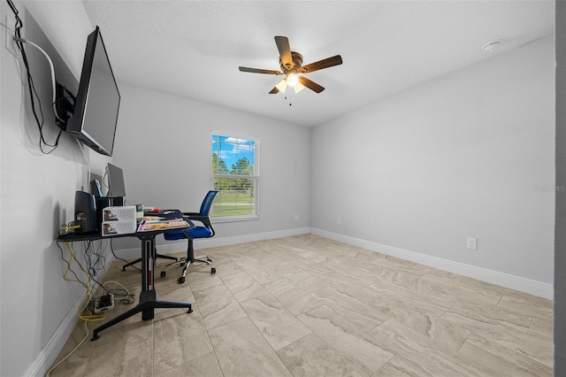 office space with baseboards and ceiling fan