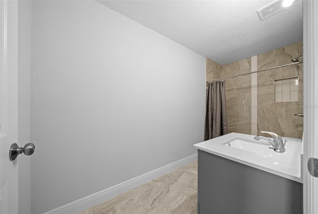 bathroom with visible vents, curtained shower, baseboards, vanity, and a textured ceiling