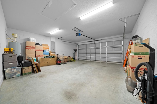 garage with concrete block wall, electric panel, and a garage door opener