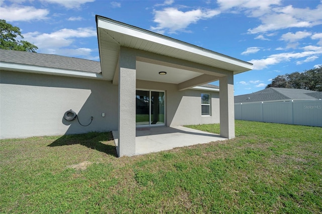back of property featuring a patio area, a lawn, stucco siding, and fence
