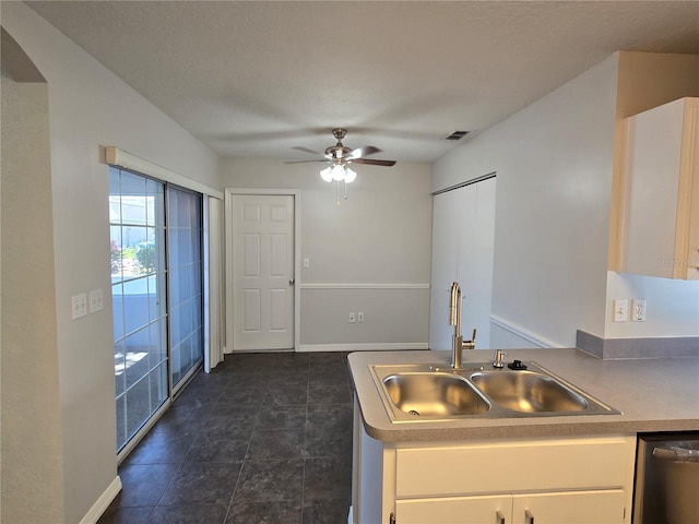 kitchen featuring visible vents, a sink, white cabinetry, a ceiling fan, and stainless steel dishwasher