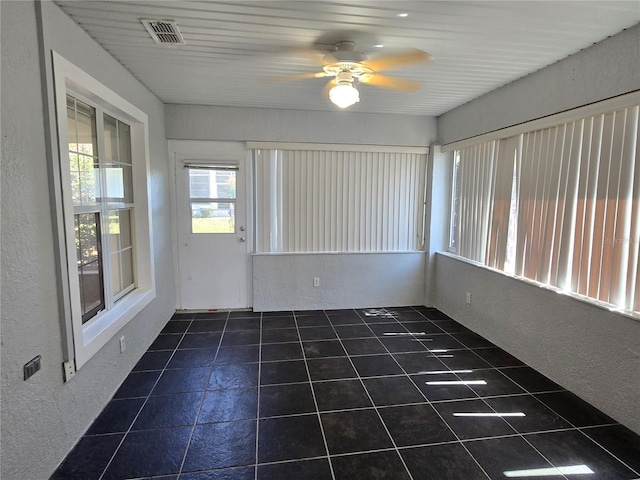 unfurnished sunroom featuring visible vents and ceiling fan