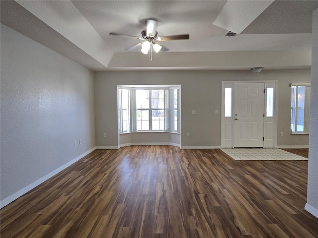 entryway with dark wood finished floors, visible vents, and baseboards