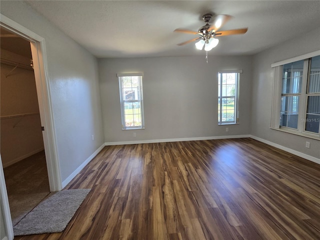 unfurnished bedroom featuring baseboards, dark wood finished floors, and a ceiling fan