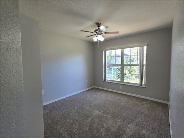 carpeted spare room featuring baseboards, a textured ceiling, a ceiling fan, and a textured wall