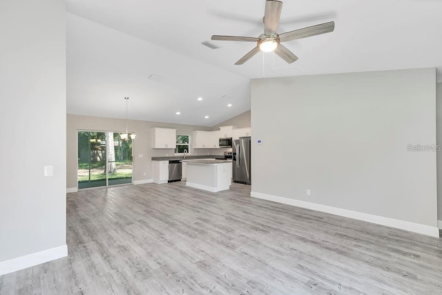 unfurnished living room with baseboards, high vaulted ceiling, recessed lighting, ceiling fan with notable chandelier, and light wood-type flooring