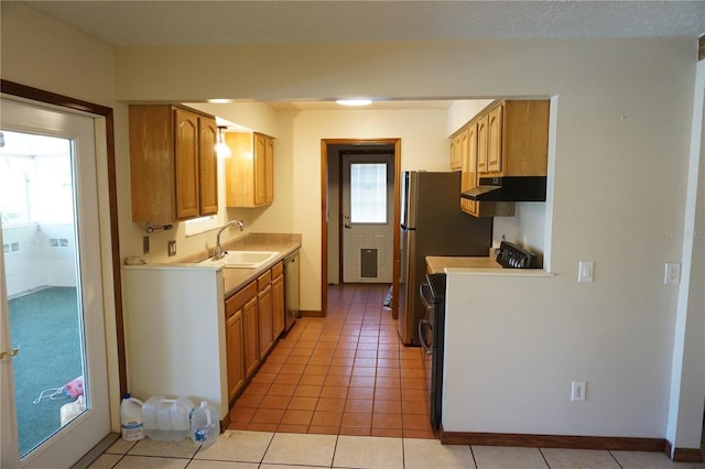 kitchen featuring a sink, under cabinet range hood, light countertops, range, and dishwasher