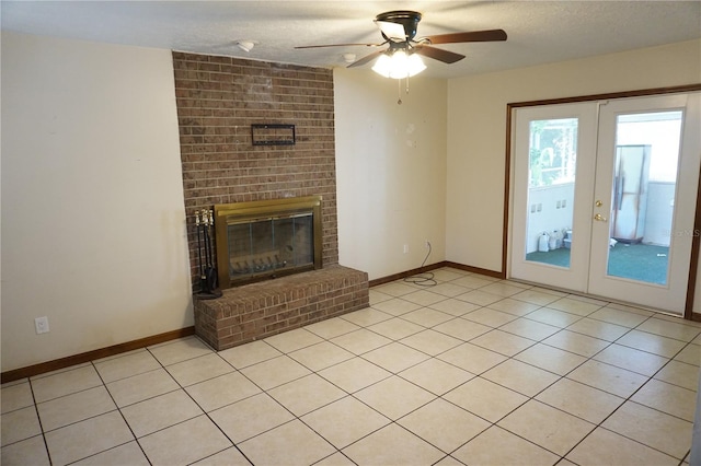 unfurnished living room with a ceiling fan, baseboards, a fireplace, french doors, and a textured ceiling