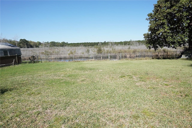 view of yard with fence and a water view